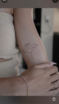 a woman's arm with a small tattoo on the left side of her arm