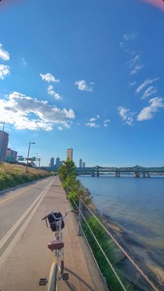 a bike parked on the side of a road next to water