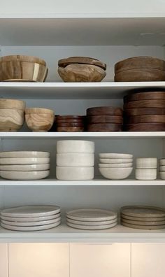 the shelves are filled with dishes and bowls