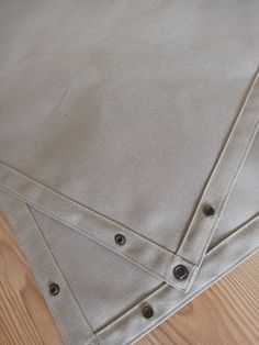 three pieces of cloth on top of each other with holes in the middle and buttons at the bottom