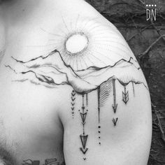 the back of a man's shoulder with arrows and mountains on it