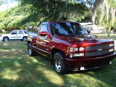 a red pick up truck parked in the grass