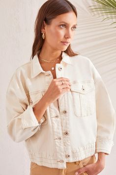 An elastic waistband and slouchy fit keep the vibes casual in this oversize jacket. It's pulled together with metal shank buttons, a collared neckline, flap patch pockets on the chest, long sleeves with zip-open cuffs, a 22" length, and stretch-enhanced denim fabric. Button-up with shirt collarOpening cuffs with zipper; flap patch pocketsElastic at waistband 22" long Machine wash delicate cycle cold water, separately, do not bleach, tumble dry low, low iron if needed. Relaxed Fit Outerwear With Pockets For Day Out, Oversized Utility Jacket With Lapel Collar For Everyday, Trendy Oversized Outerwear With Button Cuffs, Oversized Beige Utility Jacket With Button Closure, Everyday Long Sleeve Cropped Jacket With Pockets, Oversized Beige Shacket With Buttoned Pockets, Cream Collared Shacket With Pockets, Collared Cream Shacket With Pockets, Casual Neutral Outerwear With Patch Pockets