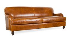 a brown leather couch sitting on top of a white floor