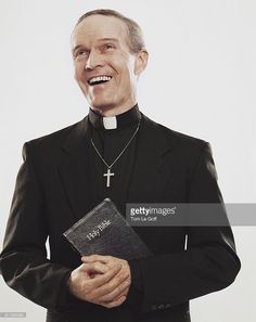 a man in a priest's outfit holding a bible