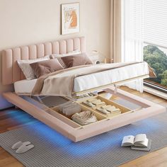 a bed with an open drawer underneath it on the floor next to a book and mouse