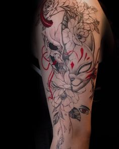 a woman's arm with flowers and skulls on it