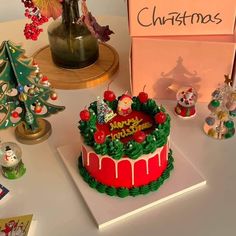 a christmas cake sitting on top of a table next to other decorations and figurines