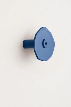 a blue plastic knob on a white surface