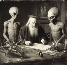 three aliens are sitting at a table and one is writing