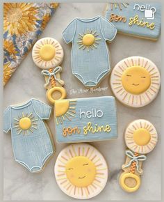 cookies decorated to look like baby clothes and the words hello, sunshine are on them