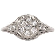 an old - fashioned diamond ring with three round diamonds in the center and two smaller round diamonds on each side