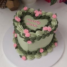 a heart shaped cake with pink roses on top