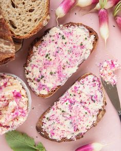 two pieces of bread with pink and green sprinkles next to some flowers