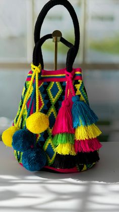 Wayuu Bags are handcrafted by the Wayuu indigenous community in Colombia, with each piece taking weeks to create. They are then adorned by skilled women heads of household, who meticulously decorate each design with high-quality crystals. This blend of tradition and exclusive craftsmanship makes these bags true artisanal treasures, representing both cultural heritage and social impact. Purse Style, Wayuu Bag, Indigenous Community, Social Impact, Purse Styles, Cultural Heritage, Purses And Bags, Crystals, High Quality