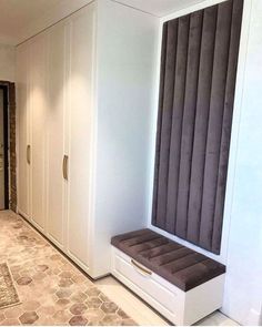 an empty hallway with white cabinets and brown cushions on the bench in front of it