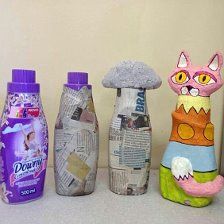 several bottles are lined up on the counter with paper mache cats and clouds in them