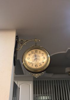 a clock hanging from the ceiling in a room