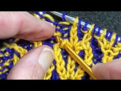 someone crocheting the stitches on a yellow and blue blanket