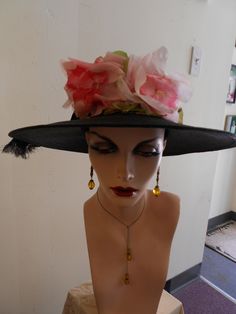 "1950\" 22\" head size, finely woven black pin wheel straw hat, with two large silk pin roses attached to front of crown. Crown is also encircled with wide gross grain black ribbon, with large round straw button securing band on side of hat. Brim is a wide perfect circle. Measurements: crown 22' round, 3\" wide brim 4\" wide circumference 24\" Condition: excellent" Victorian Evening Hats For Kentucky Derby, Vintage Black Brimmed Straw Hat, Victorian Hats For Church And Kentucky Derby, Vintage Black Costume Hats For Spring, Black Fascinator For Royal Ascot Garden Party, Black Victorian Hat For Wedding, Victorian Black Hat For Weddings, Black Victorian Wedding Hat, Vintage Black Fascinator For Kentucky Derby