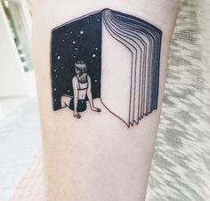 a person with a book tattoo on their arm