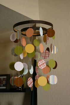 a wind chime hanging from the side of a wall in a living room with circles on it