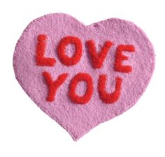 a pink felt heart with the words love you written on it in red and orange