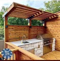 an outdoor kitchen with grill and sink under a pergolated wooden cover over it