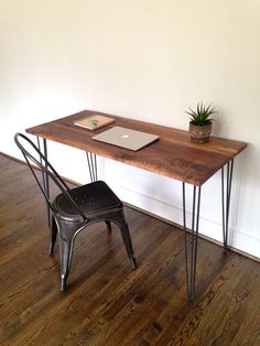 a wooden desk with metal legs and a laptop on it