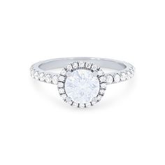 a white gold engagement ring with round diamonds on the band and an oval center stone