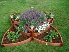 a wooden planter filled with lots of flowers on top of a lush green field