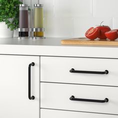 two tomatoes are sitting on the counter top next to some spices and pepper shakers