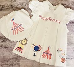 🎪This beautiful dress is perfect for Circus birthday or everyday wear.  It will have Happy Birthday or NAME/Initials at the top, 4 Circus theme designs; one on each pleat. The matching bloomers complete the entire look (please see option to purchase those). There is a listing for a boy outfit.  🎪The quality of this dress is amazing, it is made out of cotton pique, and can become an heirloom to pass to future generations!  🎪Customize this piece by adding monogram, initials, design or your chil Circus Embroidery Designs, White Short Sleeve Birthday Dress, Playful White Embroidered Dress, Fun Ruffle Dress For Birthday, Fun Ruffled Dresses For Birthdays, Fun Ruffled Dresses For Birthday, Cute Fitted Pleated Dress, Short Sleeve Ruffle Dress For Birthday, Short Sleeve Ruffled Birthday Dress