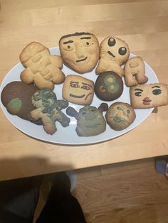 a white plate topped with cookies covered in different types of emoticions on top of a wooden table