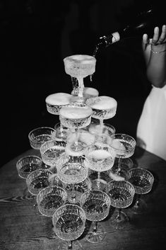 a person pouring wine into glasses on top of a table