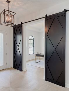 an open sliding door in the middle of a room with white walls and wood floors