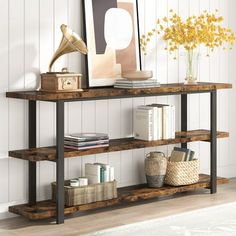 a shelf with books, pictures and other items on it next to a vase filled with flowers