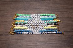 several bracelets are stacked on top of each other with gold chains and colorful beads