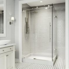 a bathroom with a walk in shower next to a white sink and mirror on the wall