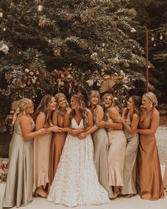 a group of women standing next to each other in front of a tree with flowers