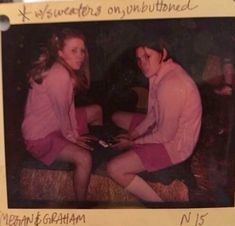 an old photo of two women sitting next to each other on a bed with writing on it