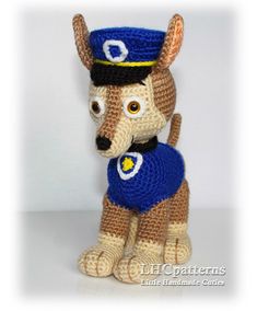 a crocheted dog with a blue shirt and hat on it's head