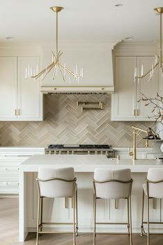 a kitchen with white cabinets and gold accents