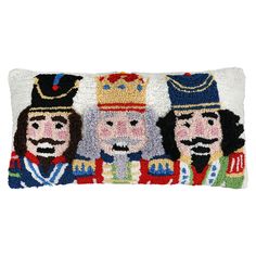 a decorative pillow with three royal figures on the front and sides, one wearing a crown