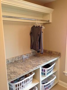 an organized closet with clothes and baskets on the shelf, next to a coat rack