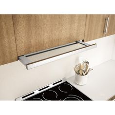 a stove top oven sitting inside of a kitchen next to a wooden cabinet and counter