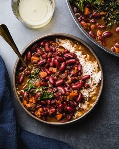 two bowls filled with beans, rice and greens