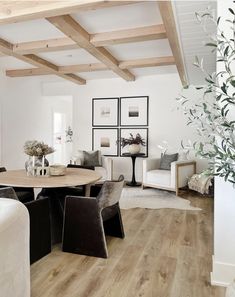 a living room filled with furniture and a wooden table in front of a white wall