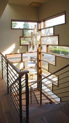 an open stairwell with wooden handrails and windows