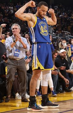 a man standing on top of a basketball court with his fist up in the air